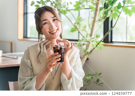 Young Asian woman drinking iced coffee in cafe, dining 124839777
