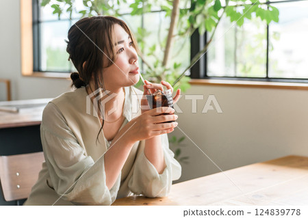 Young Asian woman drinking iced coffee in cafe, dining 124839778