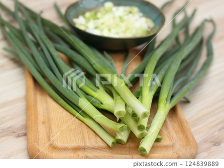 Fresh green onions on a chopping board and in a bowl. Fresh green onions on a chopping board and in a bowl. 124839889