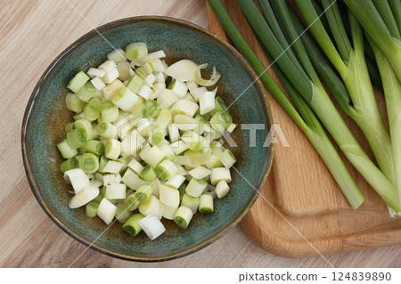 Fresh green onions on a chopping board and in a bowl. Fresh green onions on a chopping board and in a bowl. 124839890