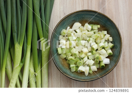 Fresh green onions on a chopping board and in a bowl. Fresh green onions on a chopping board and in a bowl. 124839891
