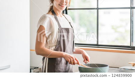 Young Asian woman cooking in the kitchen (cooking, home cooking) Young Asian woman cooking in the kitchen (cooking, home cooking) 124839900