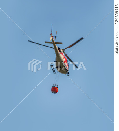 Fire fighting helicopter carry water to put out the forest fire. Fire fighting helicopter carry water to put out the forest fire. 124839918