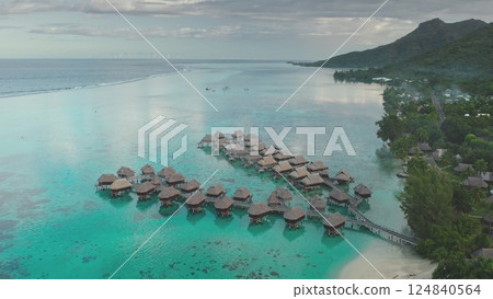 Breathtaking aerial overwater bungalows resort. Moorea, French Polynesia, vibrant turquoise lagoon, sand beach coastline. Idyllic tropical paradise. Remote wild nature, exotic summer travel background Breathtaking aerial overwater bungalows resort. Moorea, French Polynesia, vibrant turquoise lagoon, sand beach coastline. Idyllic tropical paradise. Remote wild nature, exotic summer travel background 124840564