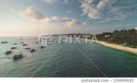 Aerial view capturing Cagban Beach at sunset, featuring traditional Philippine bangkas floating on turquoise waters alongside lush greenery and white sand, Boracay Island Aerial view capturing Cagban Beach at sunset, featuring traditional Philippine bangkas floating on turquoise waters alongside lush greenery and white sand, Boracay Island 124840685