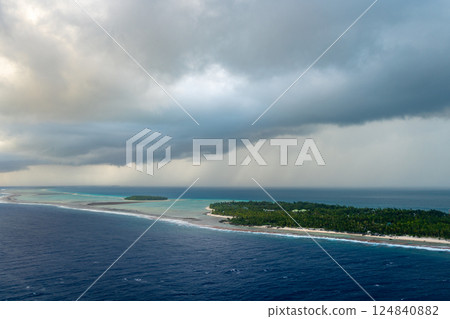 Aerial view of Tikehau atoll, French Polynesia, with cloudy sky and lagoon Aerial view of Tikehau atoll, French Polynesia, with cloudy sky and lagoon 124840882