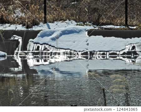 水庫岸邊積雪與融雪形成的冬日景象 124841065