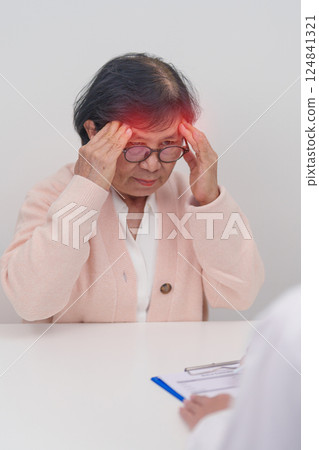Senior Woman having headache and consulting doctor to disease. Elderly health patient, Medical Diagnosis, Migraine, Brain Tumor, Brain Stroke, Dementia, neurological disorder, alzheimer, Parkinson 124841321