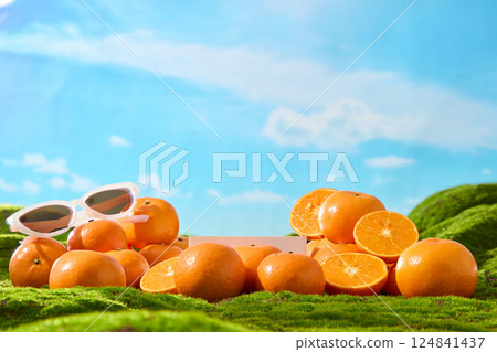 Oval-shaped sunglasses with white frames sit on ripe oranges. The center pedestal is obscured by stacked fruit, displayed on artificial green grass. Empty space for showing product or designing. Oval-shaped sunglasses with white frames sit on ripe oranges. The center pedestal is obscured by stacked fruit, displayed on artificial green grass. Empty space for showing product or designing. 124841437