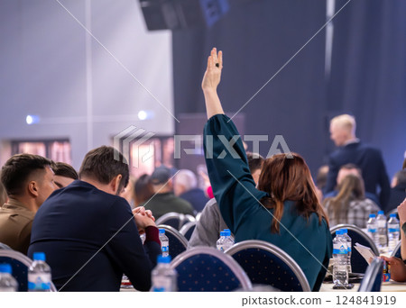 Person raising hand during business seminar or workshop with audience interaction 124841919