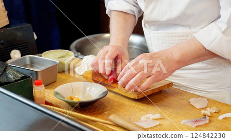 The hands of a chef preparing sushi The hands of a chef preparing sushi 124842230