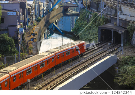 Red Train Passing by Canal in Urban City Neighborhood, Ochanomizu Dec 8 2024 124842344