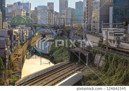 Red Train Passing by Canal in Urban City Neighborhood, Ochanomizu Dec 8 2024 124842345