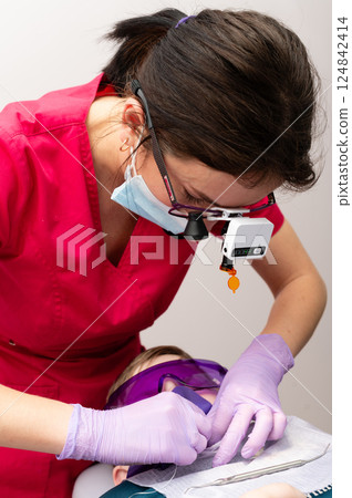 Dedicated dental professional providing care to a patient in a modern clinic during bright daylight hours, showcasing the importance of oral health in a comfortable environment Dedicated dental professional providing care to a patient in a modern clinic during bright daylight hours, showcasing the importance of oral health in a comfortable environment 124842414