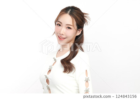 A beautiful young Asian woman with clean, fresh skin against a white background. Skincare, facial treatment, cosmetology, beauty, and spa. An elegant portrait of an Asian woman. 124843156