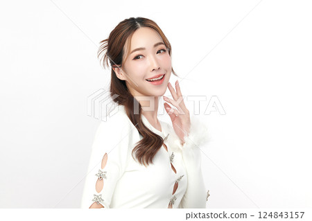 A beautiful young Asian woman with clean, fresh skin against a white background. Skincare, facial treatment, cosmetology, beauty, and spa. An elegant portrait of an Asian woman. 124843157