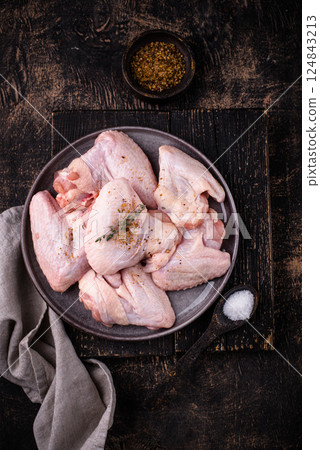 Raw chicken wings on black background. Raw chicken wings on black background. 124843213