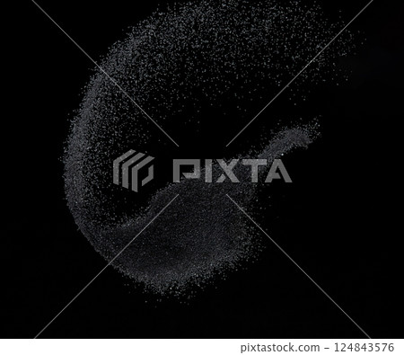 Million of black sand explosion, Photo image of falling down sands flying. Freeze shot on black background isolated overlay. Tiny Fine sand dust magnet as particle disintegrate science 124843576