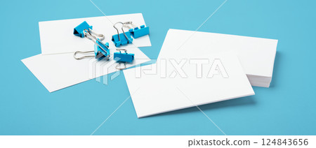 Business card mockup with binder paper clips on blue background 124843656