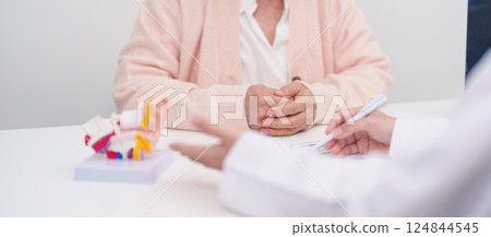 Elderly Patient consulting Doctor to Ear disease. Senior Health Medical Diagnosis. Anatomy Ear model for Atresia, Otitis Media, Pertorated Eardrum, Meniere syndrome, otolaryngologist, Hearing Loss 124844545