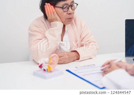 Elderly Patient consulting Doctor to Ear disease. Senior Health Medical Diagnosis. Anatomy Ear model for Atresia, Otitis Media, Pertorated Eardrum, Meniere syndrome, otolaryngologist, Hearing Loss 124844547