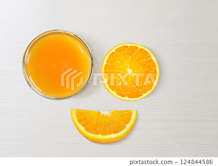 Orange juice in glass, orange slices, half orange separated on white table, top view. 124844586