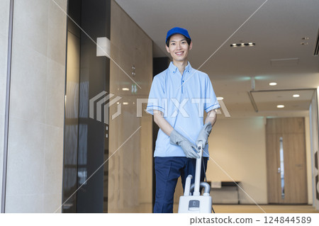 Smiling young male cleaning staff looking at camera 124844589