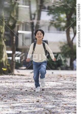A 9-year-old boy running with a school bag 124844669