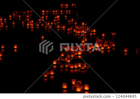 Floating lanterns on the water at night Floating lanterns on the water at night 124844695