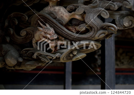 A wooden dragon carved into the shrine building 124844720