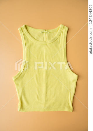 Lemon yellow cropped tank top on beige background, second-hand fashion and sustainable clothing Lemon yellow cropped tank top on beige background, second-hand fashion and sustainable clothing 124844803