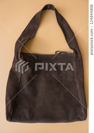 Minimalist brown suede shoulder bag on pastel background Minimalist brown suede shoulder bag on pastel background 124844806