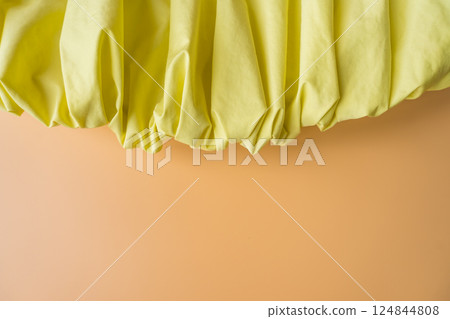 Yellow gathered fabric on pastel background, minimal composition 124844808