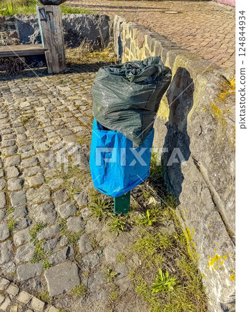 Overflowing Trash Can with Plastic Bags in Park, Litter Problem, Urban Waste. High quality photo 124844934