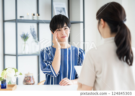 A young woman receiving counseling at a beauty salon 124845303