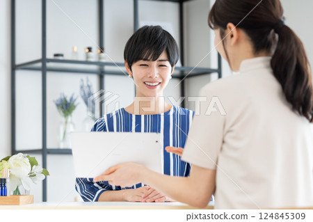 A young woman receiving counseling at a beauty salon 124845309
