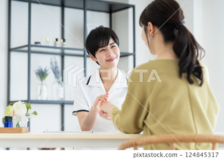 A young woman receiving counseling at a beauty salon A young woman receiving counseling at a beauty salon 124845317