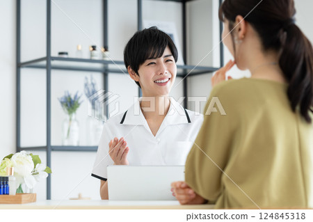 A young woman receiving counseling at a beauty salon 124845318