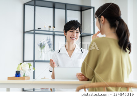 A young woman receiving counseling at a beauty salon 124845319