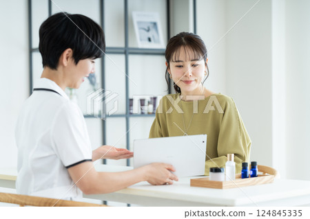 A young woman receiving counseling at a beauty salon A young woman receiving counseling at a beauty salon 124845335
