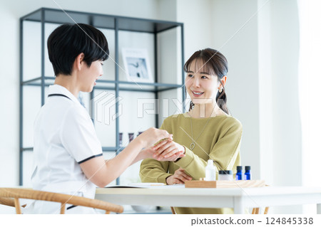 一名年輕女子在美容院接受諮詢 一名年輕女子在美容院接受諮詢 124845338
