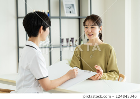 A young woman receiving counseling at a beauty salon 124845346