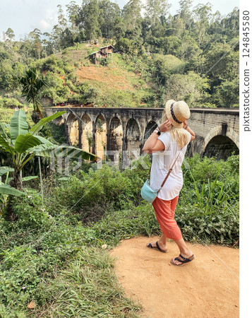 Woman enjoying view of the Nine Arch Bridge, in Demodara, Sri Lanka. Woman enjoying view of the Nine Arch Bridge, in Demodara, Sri Lanka. 124845580
