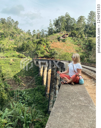 Woman enjoying view of the Nine Arch Bridge, in Demodara, Sri Lanka. 124845583