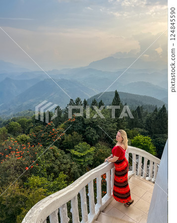 A blonde woman enjoys the view from a tower at the Ambuluwawa Temple A blonde woman enjoys the view from a tower at the Ambuluwawa Temple 124845590