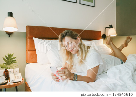 woman using smartphone in bedroom woman using smartphone in bedroom 124845610