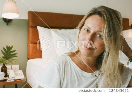Portrait of beautiful blonde woman in bedroom Portrait of beautiful blonde woman in bedroom 124845631
