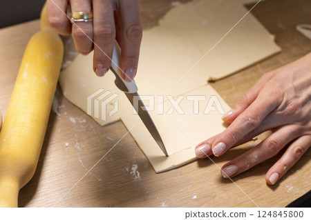 A woman cuts puff pastry A woman cuts puff pastry 124845800