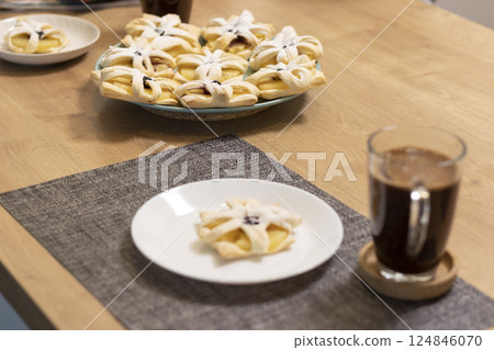 Freshly baked fruit puff pastry on the ceramic plate next to hot cup of coffee Freshly baked fruit puff pastry on the ceramic plate next to hot cup of coffee 124846070