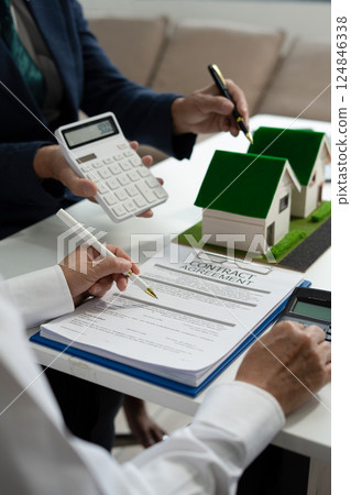 House model with agent asking costumer for contract to buy, get insurance or loan real estate or property. 124846338